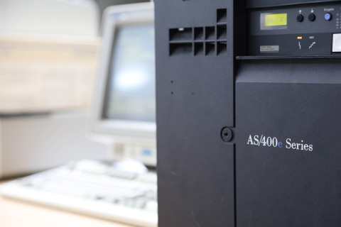 IBM AS/400 mit Terminal im Hintergrund